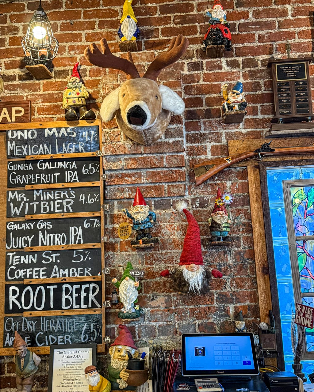 A brick wall in a Denver sandwich shop crowded with garden gnomes, a mounted moose head and chalkboard drink signs