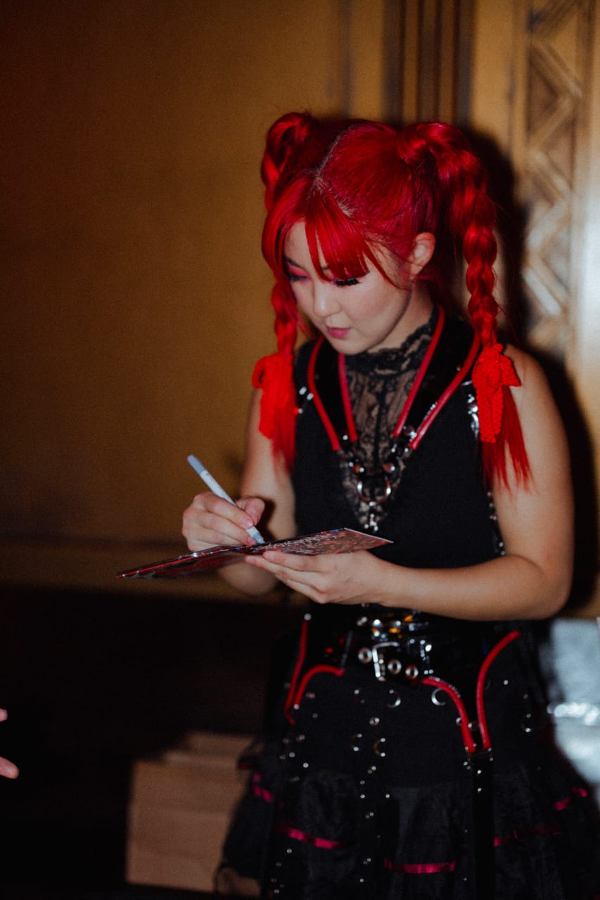 Grace Kelly signs a card at the DEADGRACE merch table after the set at the Star Theater in Portland