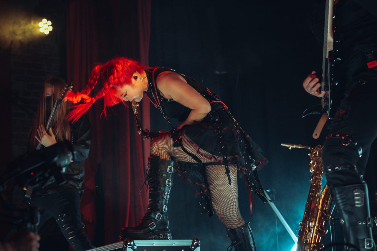 Grace Kelly headbangs with one boot on a road case, red braids swinging, between Sam Fairless and Hampus Isaksson at the Star Theater in Portland