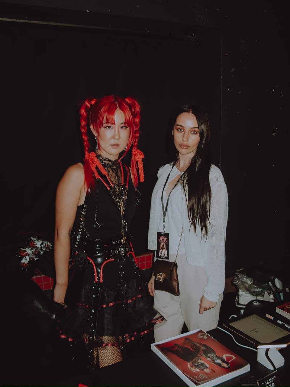 Grace Kelly at the merch table beside a guest wearing a tour laminate at The Ritz